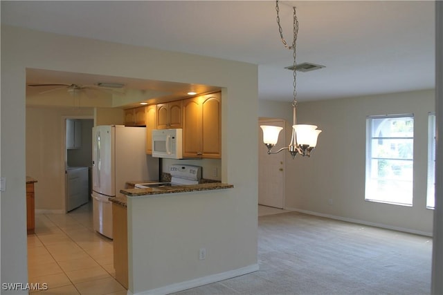 kitchen featuring white appliances, dark stone counters, pendant lighting, a notable chandelier, and light colored carpet