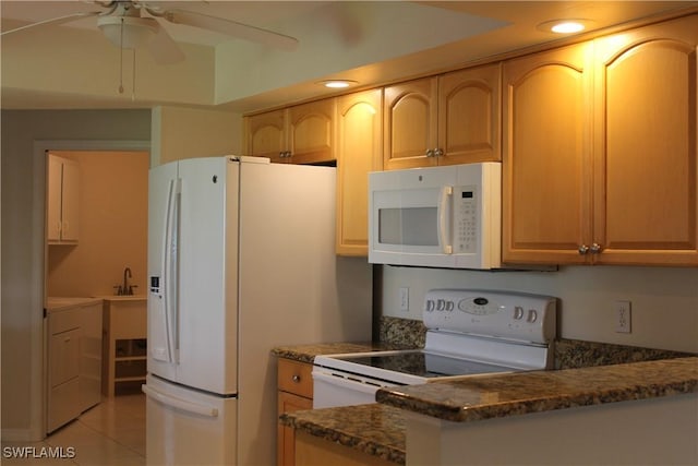 kitchen with washer / clothes dryer, white appliances, light tile patterned flooring, dark stone countertops, and ceiling fan