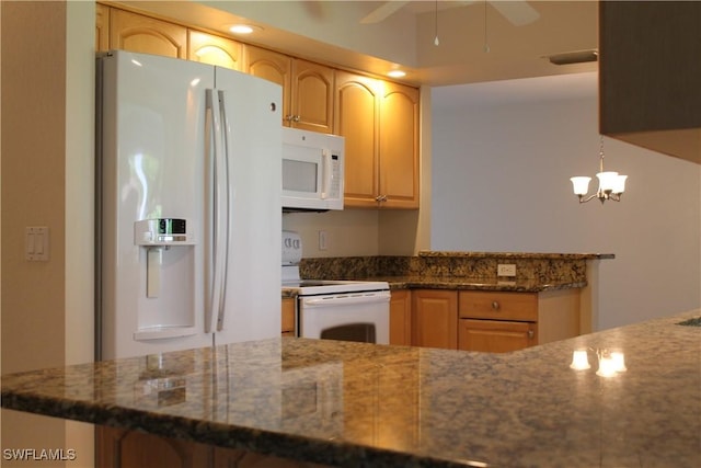 kitchen featuring decorative light fixtures, white appliances, dark stone countertops, kitchen peninsula, and ceiling fan with notable chandelier