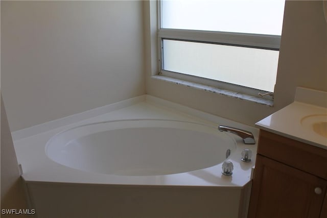 bathroom with a tub and vanity