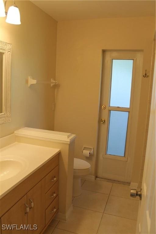 bathroom featuring toilet, tile patterned flooring, and vanity