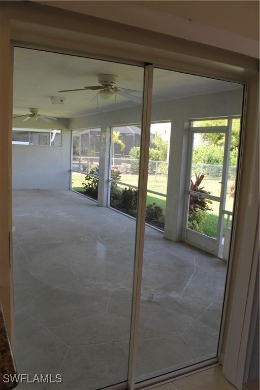 doorway with ceiling fan