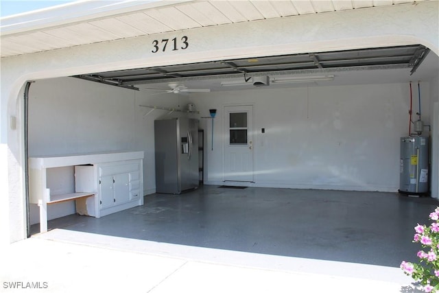 garage featuring a garage door opener, water heater, ceiling fan, and stainless steel fridge