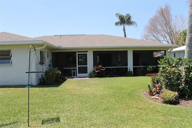 rear view of house with a yard and a sunroom