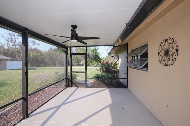 unfurnished sunroom with ceiling fan