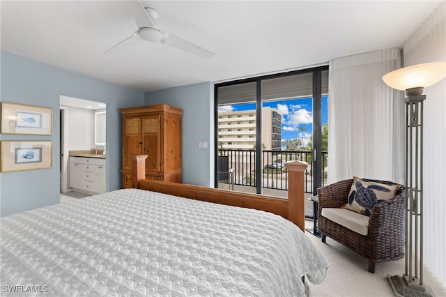 bedroom featuring ceiling fan, ensuite bathroom, a wall of windows, and access to outside