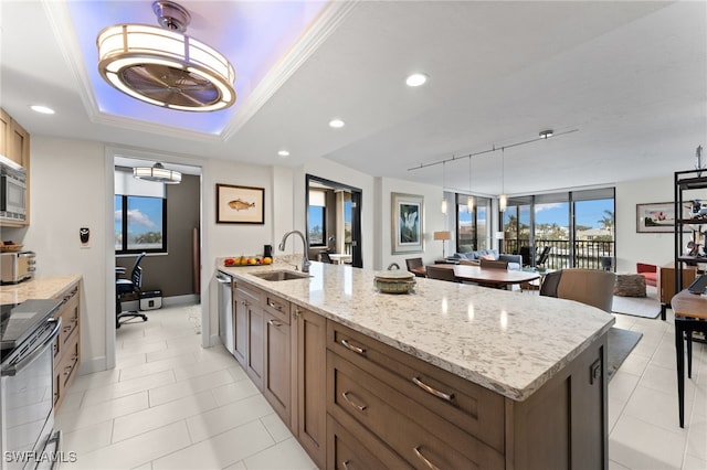 kitchen featuring appliances with stainless steel finishes, rail lighting, sink, pendant lighting, and an island with sink