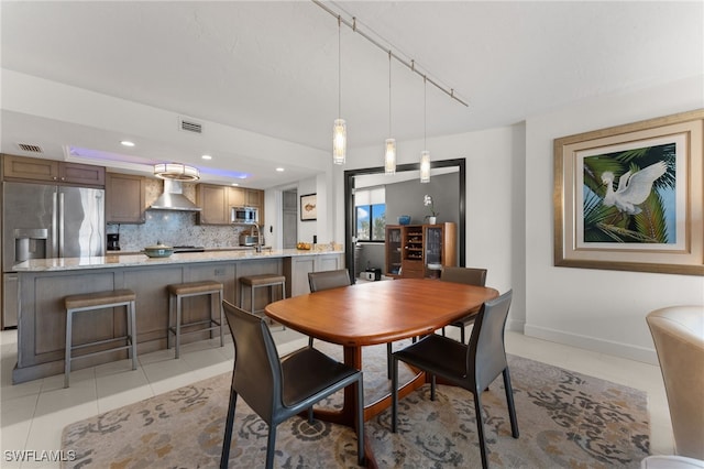 dining space featuring sink, light tile patterned floors, and track lighting