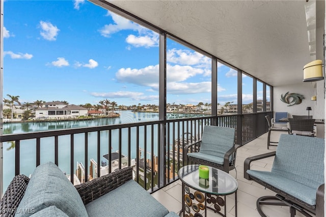 sunroom featuring a water view