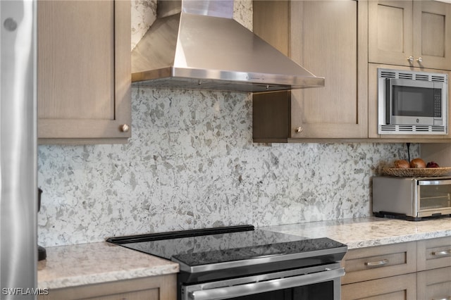 kitchen featuring wall chimney exhaust hood, light brown cabinets, backsplash, and stainless steel appliances