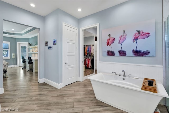 bathroom featuring a tub to relax in and crown molding