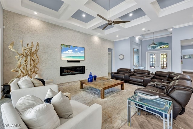 living room with ornamental molding, light wood-type flooring, ceiling fan, beam ceiling, and coffered ceiling