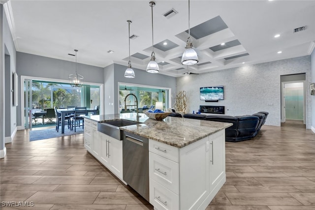 kitchen featuring pendant lighting, dishwasher, white cabinetry, sink, and a kitchen island with sink