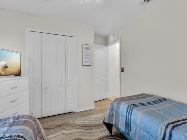 bedroom featuring ceiling fan, a closet, and light wood-type flooring