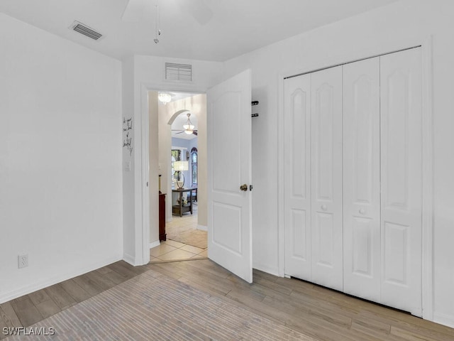 unfurnished bedroom featuring ceiling fan and a closet