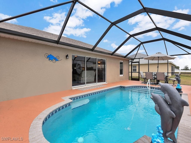 view of pool with glass enclosure and a patio area