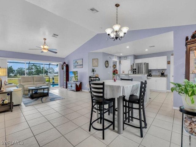 tiled dining room with ceiling fan with notable chandelier and vaulted ceiling