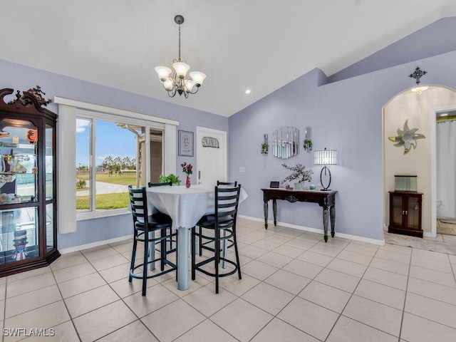 tiled dining area featuring lofted ceiling and a notable chandelier