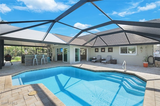 view of pool featuring a patio area, an outdoor bar, and a lanai