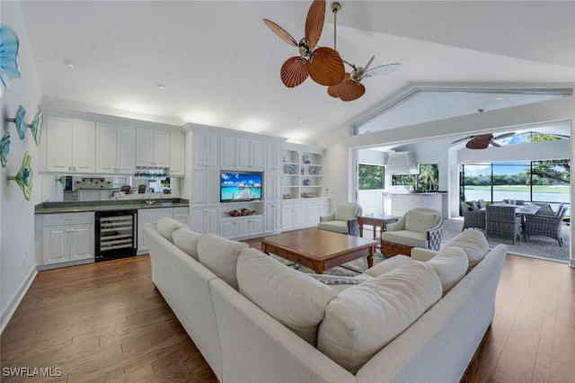 living room with hardwood / wood-style flooring, ceiling fan, lofted ceiling, and beverage cooler