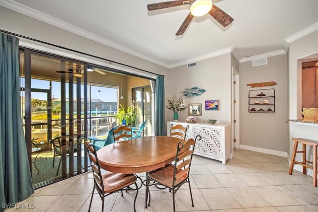 tiled dining area featuring crown molding and ceiling fan