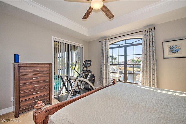 bedroom featuring a raised ceiling, ornamental molding, carpet floors, and ceiling fan