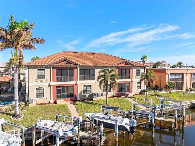 back of house featuring a water view and a yard