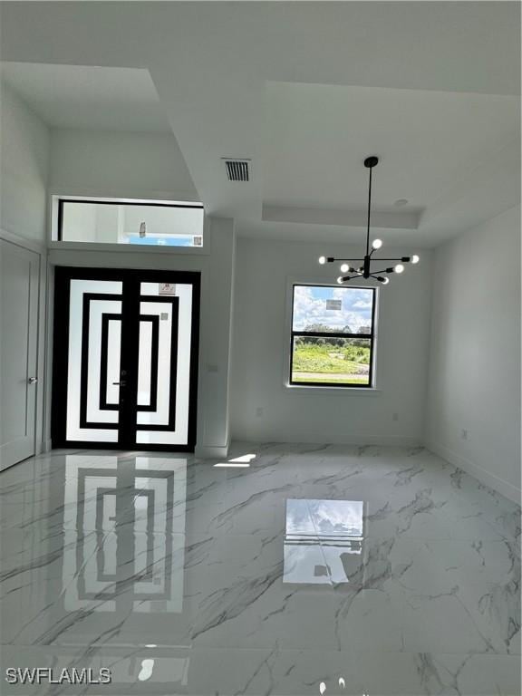 entrance foyer featuring a chandelier and a tray ceiling