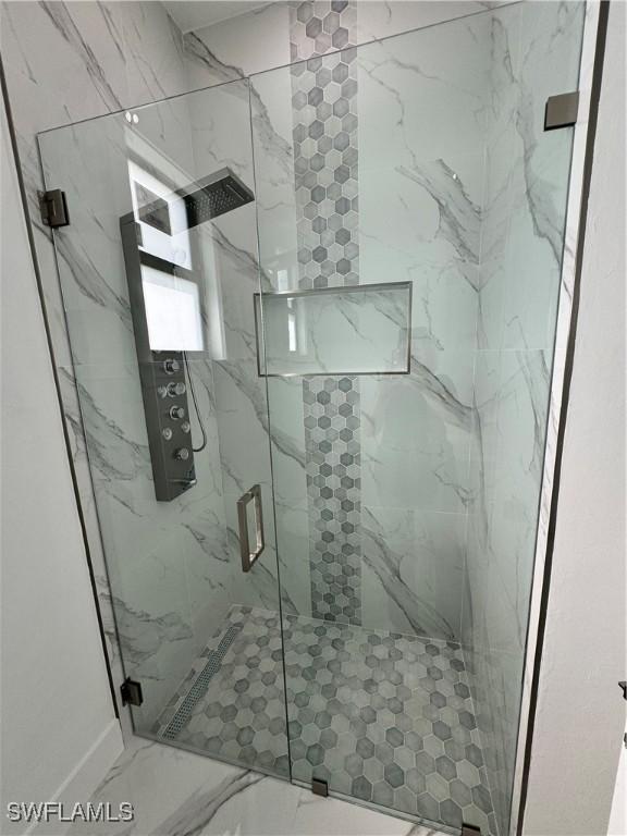 bathroom featuring a shower with shower door