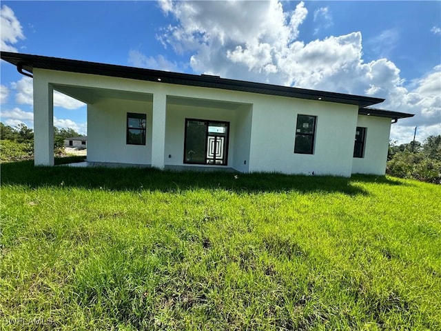 rear view of property with a lawn