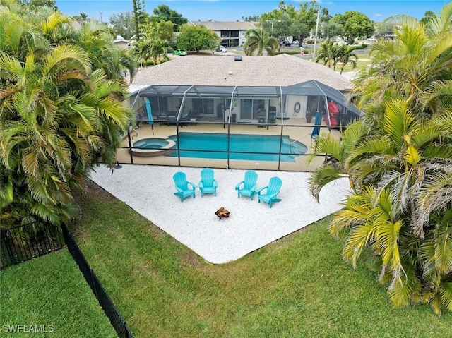 view of pool with glass enclosure, an in ground hot tub, a lawn, and a patio