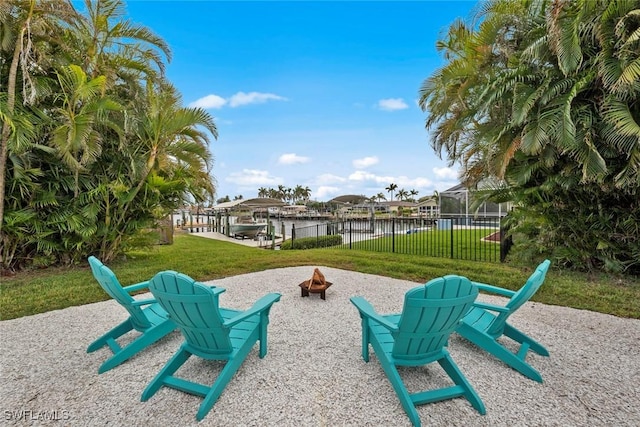 view of home's community featuring a water view, an outdoor fire pit, and a yard