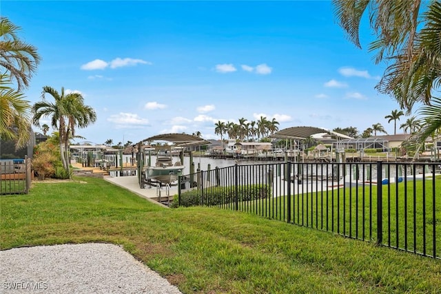 dock area with a water view and a lawn