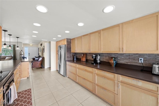 kitchen with decorative light fixtures, light brown cabinetry, and stainless steel fridge