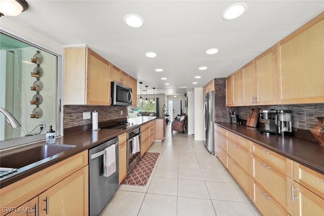 kitchen featuring light tile patterned floors, appliances with stainless steel finishes, light brown cabinetry, and hanging light fixtures