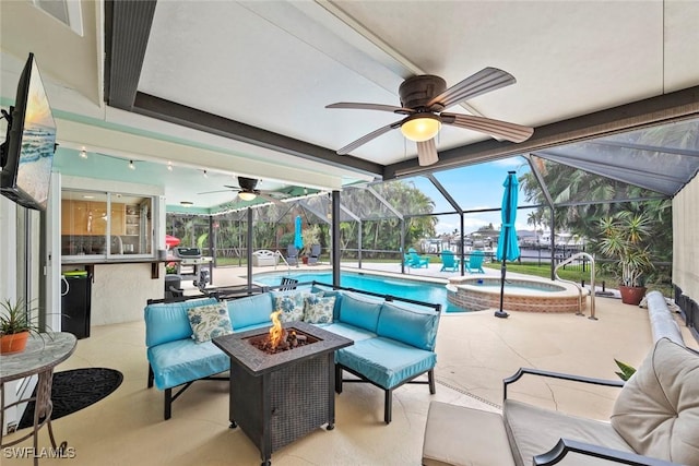 view of patio with a lanai and an outdoor living space with a fire pit