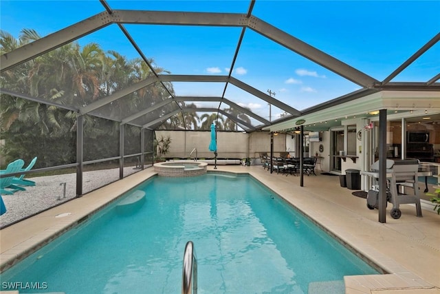 view of swimming pool with glass enclosure, a patio area, and an in ground hot tub