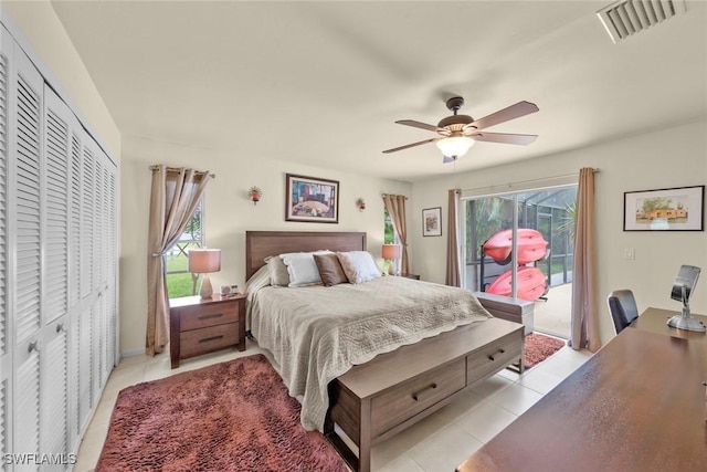 tiled bedroom featuring ceiling fan, access to exterior, multiple windows, and a closet