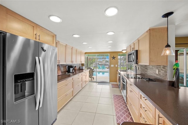 kitchen featuring hanging light fixtures, decorative backsplash, appliances with stainless steel finishes, and light brown cabinetry