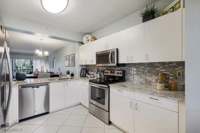 kitchen featuring stainless steel appliances, decorative backsplash, sink, white cabinetry, and light tile patterned flooring