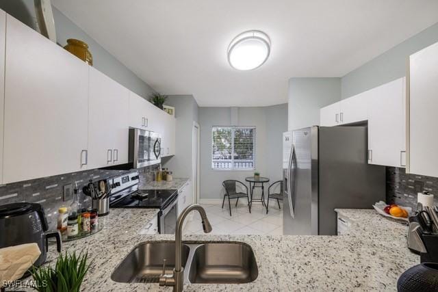 kitchen featuring stainless steel appliances, white cabinets, decorative backsplash, and sink