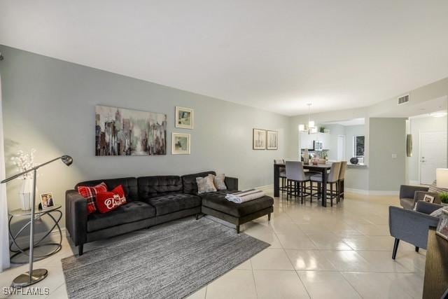 living room with a chandelier and light tile patterned floors