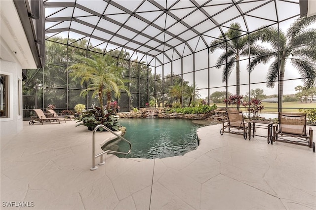 view of pool with glass enclosure and a patio area