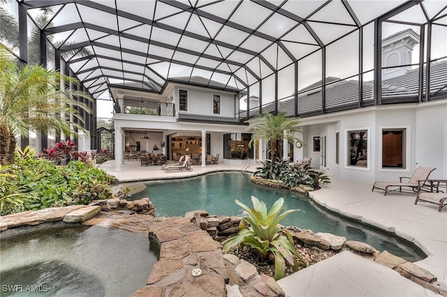 view of pool featuring ceiling fan, a patio area, and a lanai