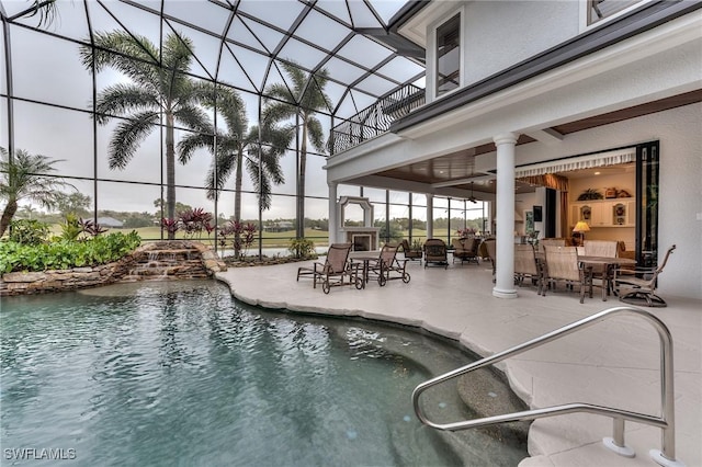 view of swimming pool featuring a water view, glass enclosure, and a patio