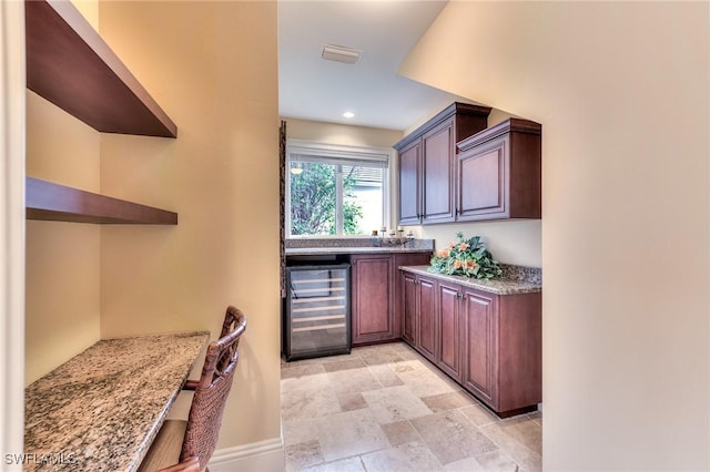 kitchen with beverage cooler and light stone countertops