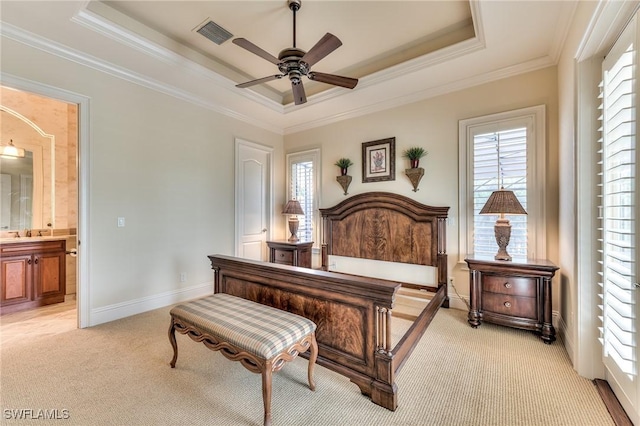 bedroom with ensuite bathroom, ceiling fan, a raised ceiling, ornamental molding, and light carpet