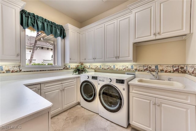 laundry area featuring cabinets, light tile patterned floors, washing machine and clothes dryer, and sink