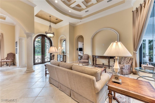 living room with a high ceiling, coffered ceiling, ornamental molding, french doors, and decorative columns