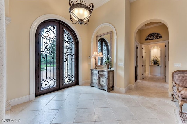 entryway with french doors, a towering ceiling, and a wealth of natural light